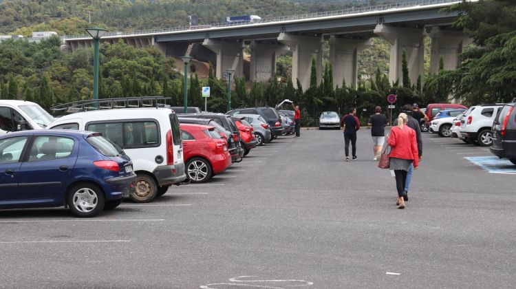 Diverses persones tornant al seu cotxe després d'haver comprat als establiments del Pertús. ACN