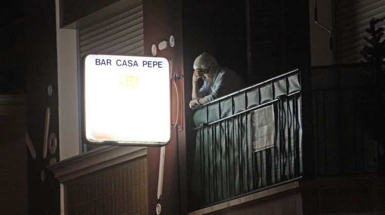 La propietària de l'immoble observant els treballs policials des del balcó de damunt el bar © M. Estarriola