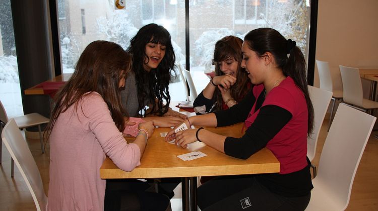 Alguns alumnes jugant a cartes mentre a fora continua nevant © ACN