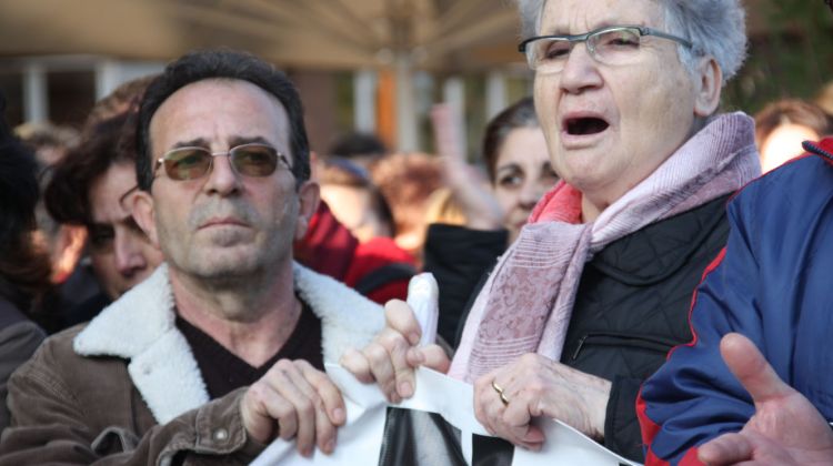 Dos manifestants subjecten una pancarta i criden els lemes de la protesta © ACN