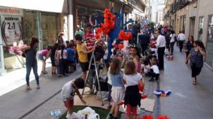 Escolars decorant els arbres instal·lats al carrer Nou © ACN