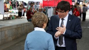 L'alcalde i candidat a la reelecció, Carles Puigdemont, conversa amb una veïna a la zona del Mercat del Lleó © ACN