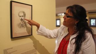 La directora del Museu d'Art de Girona, Carme Clusellas, davant de l'autoretrat que va fer-se Prudenci Bertrana © ACN