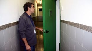 Un dels funcionaris mostra com les habitacions estan obertes i ja no hi ha panys © ACN