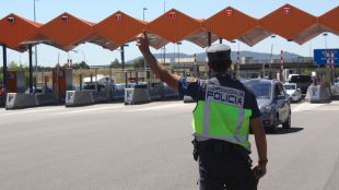 Un agent de la policia espanyola aturant un vehicle, aquest matí © ACN