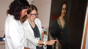Les dues restauradores del Museu d'Art al costat de l'oli 'Retrat d'una suposada heroïna de Santa Bàrbara' © ACN