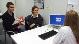 En Gerard i la Sandra, amb la seva filla Carla, passant consulta a l'Hospital d'Olot © ACN
