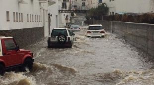 Part de la riera de Cadaqués inundada pel temporal amb vehicles circulant-hi