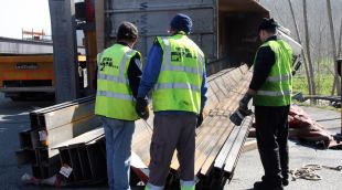 Operaris de la grua treballant en la retirada de les bigues que han quedat a peu de l'AP-7