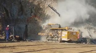 Un operari amb la màquina perforadora que trinxava el talús des de la platja de Sa Conca