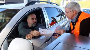 Un conductor agafat un prospecte a dins del qual hi ha inserit el dispositiu RondaGi