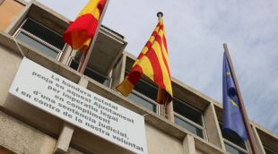 La bandera espanyola onejant amb el cartell de protesta a sota