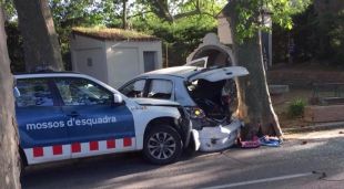 El cotxe encastat entre un arbre i el vehicle dels mossos