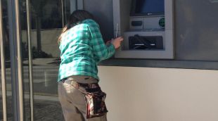 Una operària reparant el caixer el Banc Popular de Llagostera