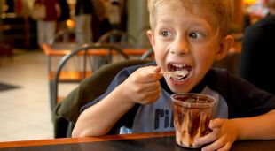 Un infant menjant un gelat en un restaurant