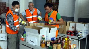 Voluntaris distribuint menjar en caixes a la seu del Banc dels Aliments de Girona