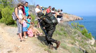 Un militar accedeix a les instal·lacions del càmping de l'Escala davant l'expectació de diversos clients del complex