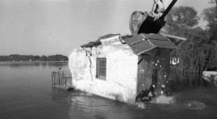 Una retroexcavadora derruint una de les antigues casetes de l'Estany
