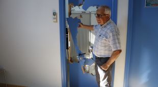 L'alcalde d'Esponellà, Joan Farrés, mostra la porta del dispensari que la Guàrdia Civil va destrossar