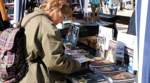 Una lectora mira diversos llibres en una parada, aquest matí