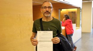 Primer pla d'un dels denunciants amb el paper a la mà que certifica que ha donat poders als procuradors i advocats