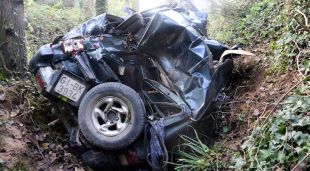 Pla del darrere del cotxe de la dona bolcat a la riera