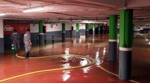 Uns operaris traient aigua d'un aparcament subterrani d'un supermercat de Palafrugell