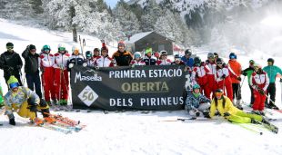 Els primers esquiadors de la Masella darrera una pancarta