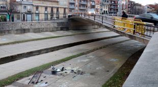El pont de l'Areny de Girona amb part de la tanca destrossada i les restes del cotxe