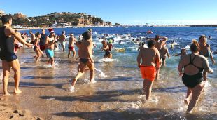 Participants entrant a l'aigua en el primer bany de l'any a la platja de Sant Feliu de Guíxols