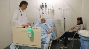 Un metge atenent un pacient en un box d'urgències, avui a l'hospital d'Olot