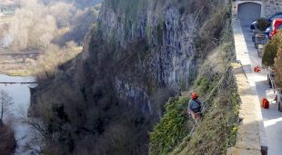 Un operari fent la neteja de la cinglera de Castellfollit de la Roca