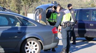 Efectius de la policia espanyola registrant el maleter d'un vehicle a l'accés a l'autopista a La Jonquera