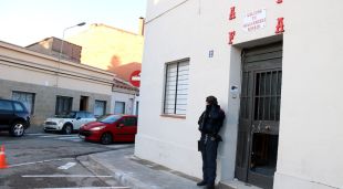 Un agent dels Mossos d'Esquadra custodia l'entrada de la seu dels 'Àngels de l'Infern'