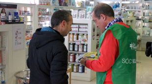 Un voluntari explica la campanya Medicaments Solidaris en una farmàcia de Girona
