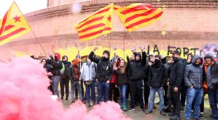 Els manifestants davant la subdelegació del govern espanyol a Girona, amb la façana pintada de groc