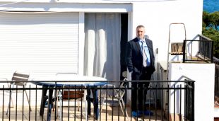 Un membre de la comitiva judicial investigant el domicili on s'ha produït el crim