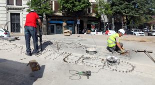 Dos operaris traient les lletres de 'Plaça Constitució' que formaven els brolladors
