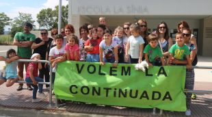 Un grup de pares i alumnes protestant davant l'escola La Sínia de Calonge per reclamar la jornada continuada