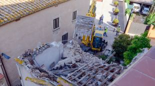 L'excavadora enderrocant l'habitatge adossat a la muralla de Llagostera aquet matí