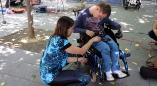 L'Arnau amb la seva fisioterapeuta mentre fa servir la cadira de rodes