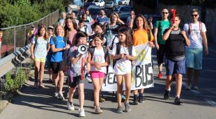 Els pares i alumnes de l'escola de Montjuïc baixant avui pels carrers del barri amb pancartes i xiulets