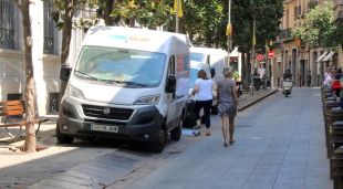 El Carrer Santa Clara de Girona amb tres furgonetes de repartiment a sobre de la vorera per falta d'espai