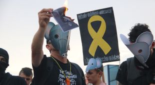 Un manifestant contrari a la presència del Rei a Aiguaviva crema una foto del monarca