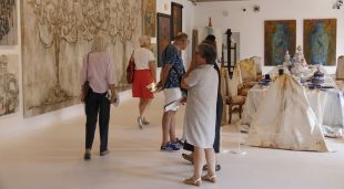 Visitants passejant per l'exposició de 'L'atelier' de Pepa Poch al Monestir de Sant Feliu de Guíxols