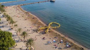 Els veïns de Roses fent el llaç humà damunt la platja