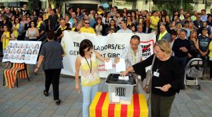 Els treballadors de la Generalitat a Girona dipositant paperetes en urnes per commemorar l'1-O