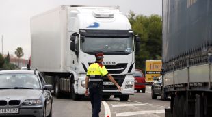 Un Mosso aturant un camió a l'N-340, a l'alçada de Roda de Berà per on no hauria de circular
