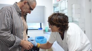 Un pacient portador d'ostomia i una infermera durant una cura