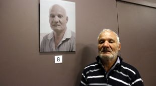 En Mustapha Chami, un dels participants del projecte de la Creu Roja, al costat del seu retrat